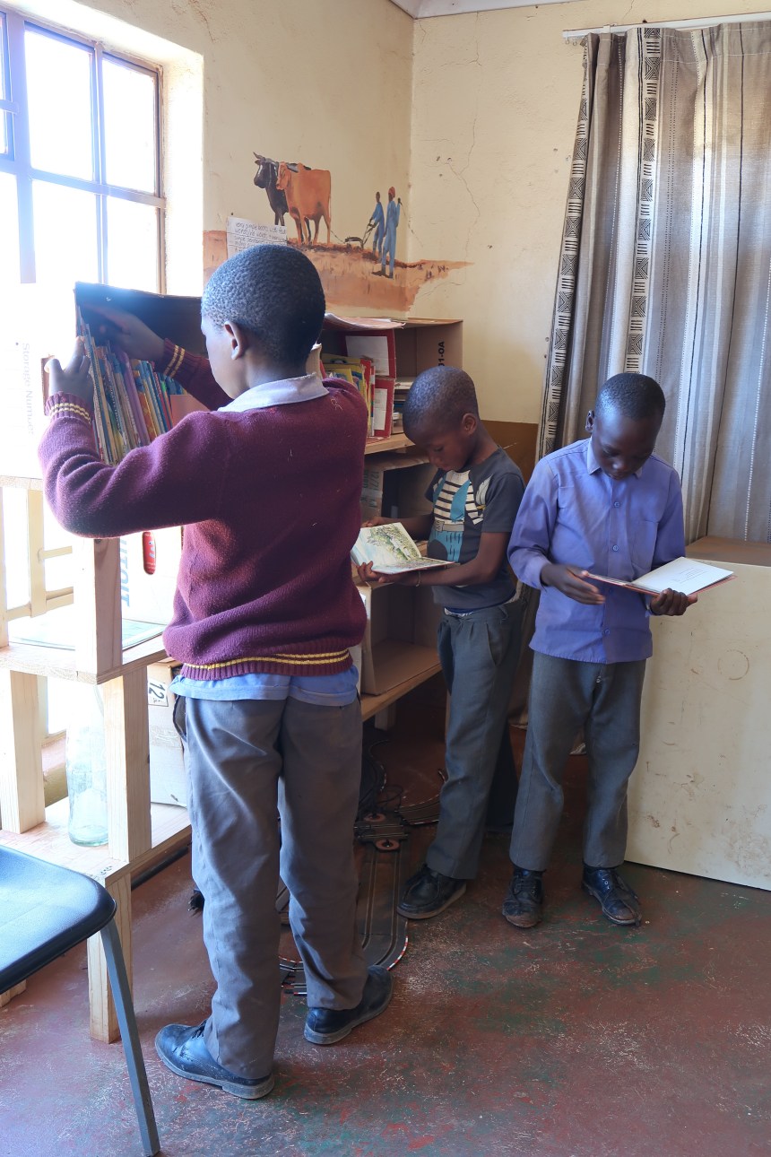 three little boys look at books