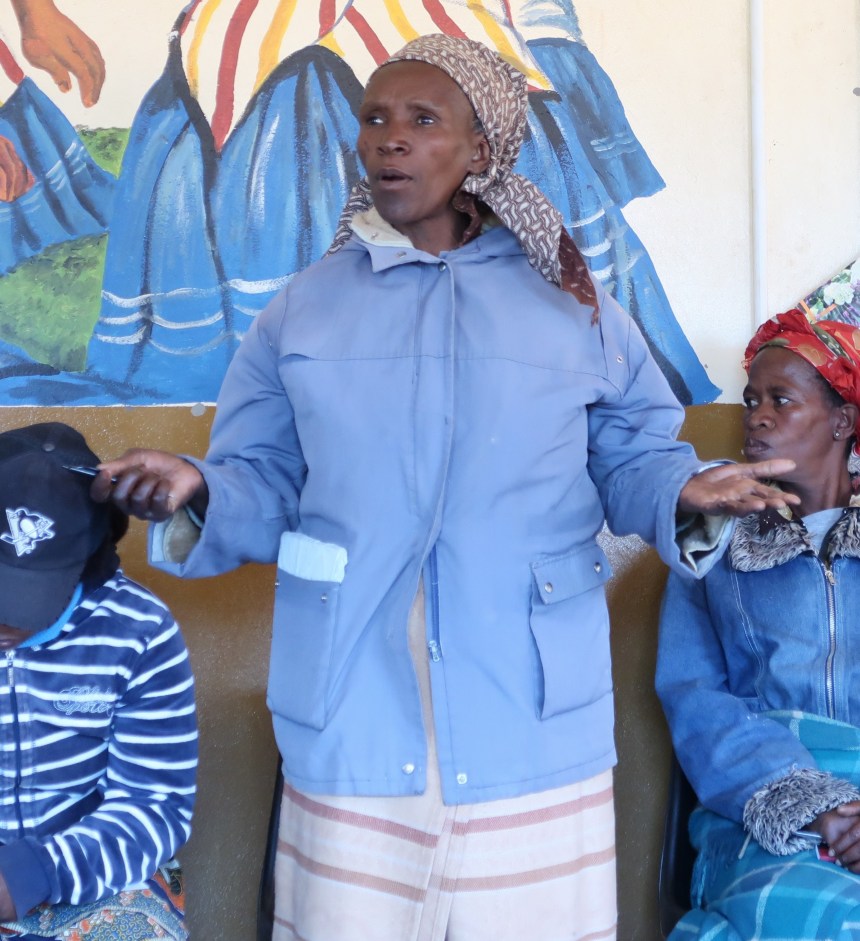 a woman stands and speaks during the Malealea Development Trust's HIV/AIDs support group meeting in Lesotho, Southern Africa