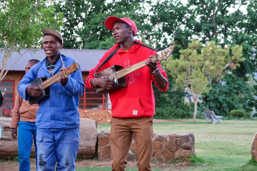 two musicians play on traditional homemade Basotho instruments while performing outdoors at the Malealea Lodge, photo by Kelly Benning