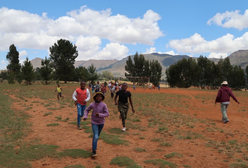 children run laps around the soccer field during Malealea Development Trust's Children's Day in Lesotho, Southern Africa