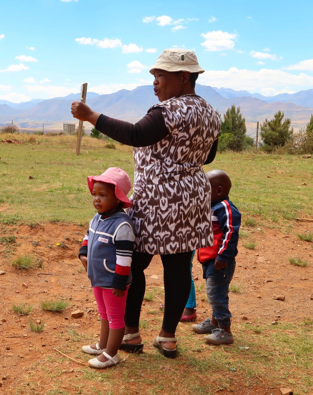 Malealea Development Trust Social Care Worker cheering on running children on Children's Day, photo by Kelly Benning