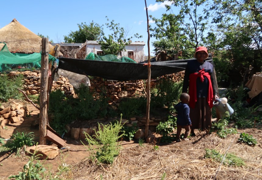 a woman and a little boy in a garden in Malealea, Lesotho