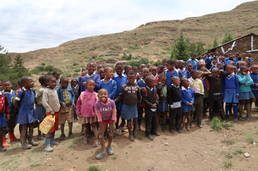 a group of children gather for photos outside their rural school in mountainous Malealea, Lesotho