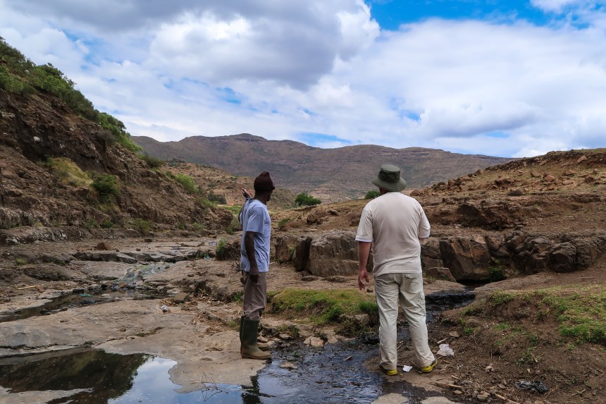 A local man shows a Dutch fundraiser a second source that could be converted into a pipeline for Ha Raboletsi, a village in Roma, Lesotho, Southern Africa, photo by Kelly Benning